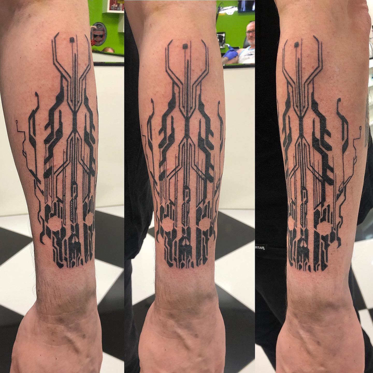 Geometric cyberpunk tattoo on forearm, featuring complex circuit-like patterns in black ink